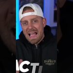 Man wearing backwards white cap and Diablo Immortal hoodie speaking to camera indoors