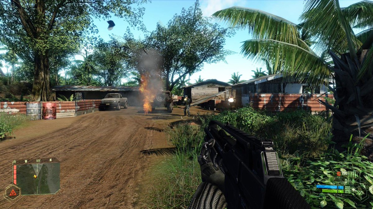 First-person view of a soldier holding a rifle in a burning village combat scene