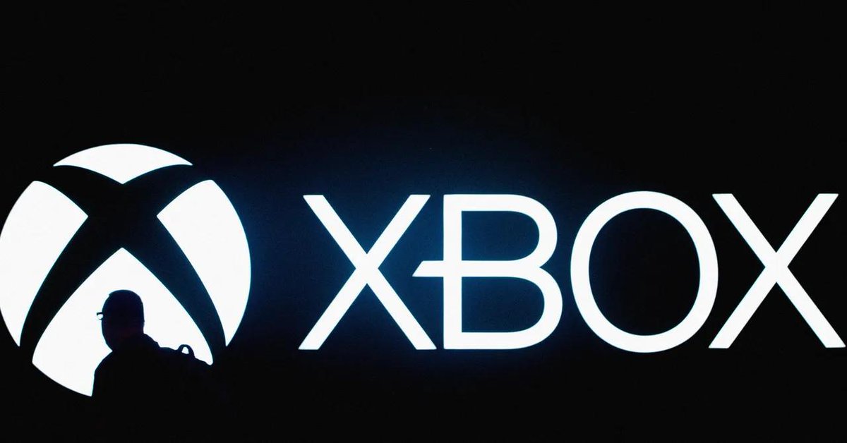 Silhouetted person walking past a large illuminated Xbox logo and wordmark on black background