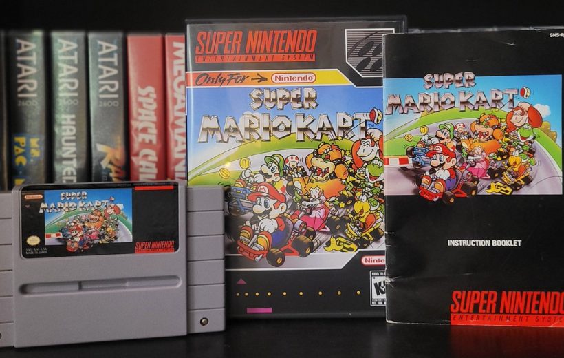 Super Mario Kart SNES cartridge, box, and instruction booklet displayed on shelf.