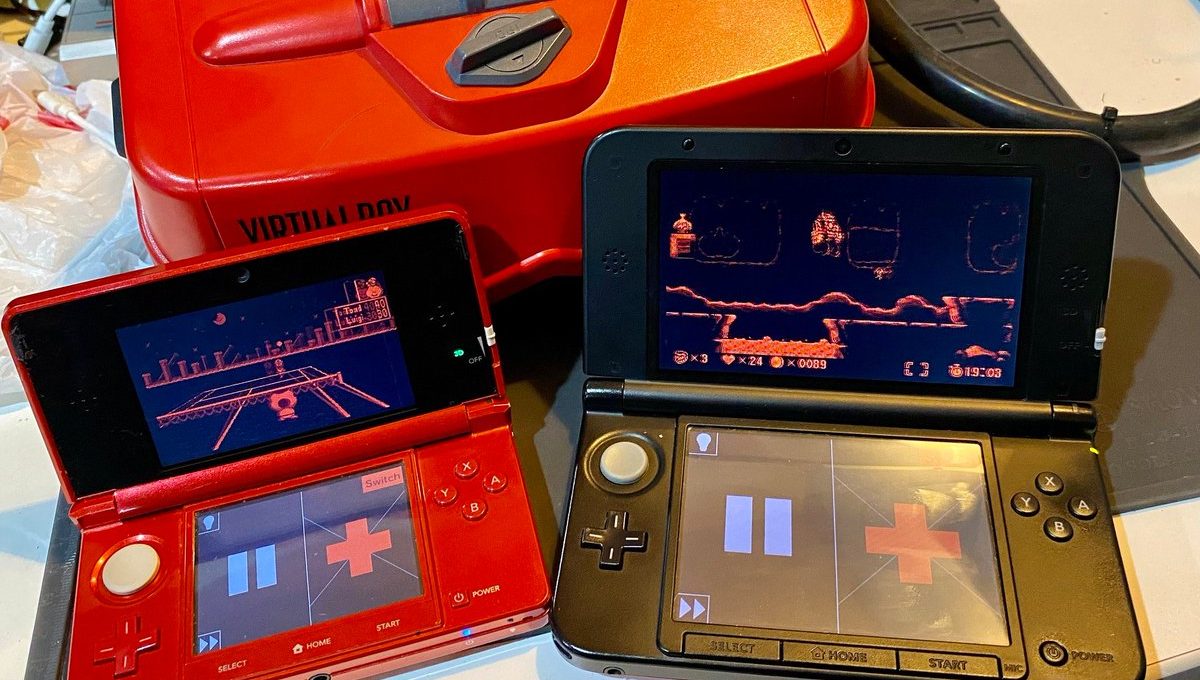 Two open Nintendo 3DS consoles showing retro red-tinted game screens beside a Virtual Boy.